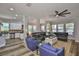 Open living room featuring wood floors, large leather couch, two blue chairs, and views of the kitchen at 5710 Tortoise Pl, Apollo Beach, FL 33572