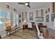 Well-lit home office features plantation shutters, hardwood floors, and golf-themed décor at 5710 Tortoise Pl, Apollo Beach, FL 33572