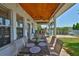Outdoor patio with a wood-look ceiling, outdoor kitchen, ceiling fans, furniture, and a view of the canal at 5710 Tortoise Pl, Apollo Beach, FL 33572