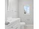 Bright bathroom featuring a white vanity, toilet, and natural light from the window at 6012 Flora Ter, Apollo Beach, FL 33572