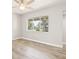 Bright bedroom with hardwood floors and a large window overlooking a beautiful, landscaped outdoor space at 6012 Flora Ter, Apollo Beach, FL 33572