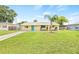 Charming home featuring a well-maintained lawn, a palm tree, and a colorful front door at 6012 Flora Ter, Apollo Beach, FL 33572