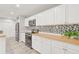 Updated kitchen features white cabinets, stainless appliances, and wood countertops at 6012 Flora Ter, Apollo Beach, FL 33572