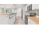 Bright kitchen offers stainless steel appliances, wood countertops, and a neutral tile backsplash at 6012 Flora Ter, Apollo Beach, FL 33572