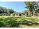 Backyard featuring a firepit, sliding glass doors, and a green lawn at 604 Kinnear Dr, Brooksville, FL 34601