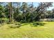 This spacious backyard has a firepit, and large trees around the border of the lot at 604 Kinnear Dr, Brooksville, FL 34601