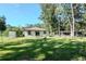 Backyard featuring a firepit, sliding glass doors, and a green lawn at 604 Kinnear Dr, Brooksville, FL 34601