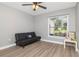 This room features a futon, a ceiling fan, and natural light from the window at 604 Kinnear Dr, Brooksville, FL 34601