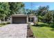 Charming single-story home featuring a brick driveway, a well-kept lawn and a two-car garage at 604 Kinnear Dr, Brooksville, FL 34601