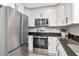 Modern kitchen featuring white cabinets, granite countertops, and stainless steel appliances, offering a clean and functional space at 604 Kinnear Dr, Brooksville, FL 34601