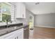 Modern kitchen features granite counters, stainless appliances, and sliding glass doors to backyard at 604 Kinnear Dr, Brooksville, FL 34601
