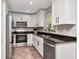 Modern kitchen featuring white cabinets, granite countertops, stainless steel appliances and a window view at 604 Kinnear Dr, Brooksville, FL 34601