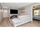 Open living room featuring hardwood floors, a large TV, and a view into the bedroom at 604 Kinnear Dr, Brooksville, FL 34601