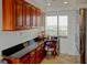Wet bar with granite counters and cherry cabinets, next to stainless steel refrigerator and window at 650 Island Way # 606, Clearwater Beach, FL 33767