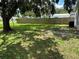 Large, grassy backyard with mature trees and a privacy fence at 7651 46Th N Way, Pinellas Park, FL 33781
