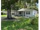 Charming single-story home featuring a screened porch, well-maintained lawn, and mature shade trees at 7651 46Th N Way, Pinellas Park, FL 33781