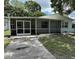 Home exterior featuring a screened porch and walkway leading to the front door at 7651 46Th N Way, Pinellas Park, FL 33781