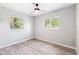 Cozy bedroom featuring a ceiling fan, two windows, and durable wood-look flooring at 7891 67Th N St, Pinellas Park, FL 33781