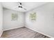 Bedroom with gray walls, wood-look flooring, ceiling fan, and two windows at 7891 67Th N St, Pinellas Park, FL 33781