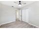 Bedroom with light gray walls, wood-look flooring, closet, and ceiling fan at 7891 67Th N St, Pinellas Park, FL 33781