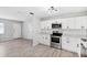 Newly renovated kitchen with stainless steel appliances, white cabinetry, subway tile, and open access to the living space at 7891 67Th N St, Pinellas Park, FL 33781