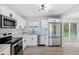 Modern kitchen featuring stainless steel appliances, white cabinets, subway tile backsplash, and sleek black hardware at 7891 67Th N St, Pinellas Park, FL 33781