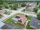 Aerial view of a house with solar panels, a screened in patio, and a well-manicured lawn in a quiet neighborhood at 8110 Damara Dr, New Port Richey, FL 34653