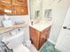 Bathroom featuring a marble sink, wooden cabinets, and an attached toilet at 8110 Damara Dr, New Port Richey, FL 34653