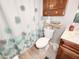 Cozy bathroom featuring a decorative shower curtain, wooden cabinet, and a beige ceramic tiled floor at 8110 Damara Dr, New Port Richey, FL 34653