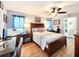 Bright bedroom features a ceiling fan, wood floors, and an ensuite bathroom at 8110 Damara Dr, New Port Richey, FL 34653