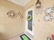 Charming front door adorned with a floral wreath, complemented by decorative wall art at 8110 Damara Dr, New Port Richey, FL 34653