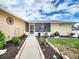 Charming front yard with a landscaped walkway leading to a screened-in porch under a cloudy sky at 8110 Damara Dr, New Port Richey, FL 34653