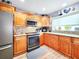 Modern kitchen features stainless steel appliances, wood cabinets and granite countertops at 8110 Damara Dr, New Port Richey, FL 34653