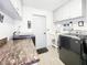 Well-lit laundry room featuring modern washer and dryer, countertop, white cabinets and tiled floor at 8110 Damara Dr, New Port Richey, FL 34653