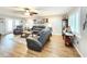 Inviting living room featuring wood floors, neutral walls, and ample seating under a ceiling fan at 8110 Damara Dr, New Port Richey, FL 34653