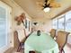 Well-lit enclosed patio with outdoor seating, a ceiling fan, and decorative elements, creating an inviting ambiance at 8110 Damara Dr, New Port Richey, FL 34653