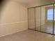 An empty bedroom with tiled floor features a large mirrored sliding door closet at 9100 Dr Martin Luther King Jr N St # 303, St Petersburg, FL 33702