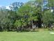 Open green space with picnic table and mature trees at 9100 Dr Martin Luther King Jr N St # 303, St Petersburg, FL 33702
