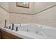Close up of the bathroom's modern soaking tub with elegant fixtures and marble tile, a perfect spa-like retreat at 9220 Hidden Water Cir, Riverview, FL 33578