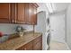 Well-equipped laundry room with granite countertops, ample storage, and modern stacked washer and dryer for easy chores at 9220 Hidden Water Cir, Riverview, FL 33578