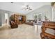 Open-concept living area with tile flooring, a ceiling fan, custom built-in entertainment center, and access to the outdoor space at 9220 Hidden Water Cir, Riverview, FL 33578
