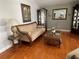 Cozy living room featuring a tan sofa, wood floors, and decorative furniture with ornate details at 9220 Hidden Water Cir, Riverview, FL 33578