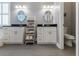 Bright bathroom featuring double vanities, round mirrors and decorative shelving at 10015 Brompton Dr, Tampa, FL 33626
