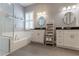 Bright bathroom featuring double vanities, soaking tub, and large glass enclosed shower at 10015 Brompton Dr, Tampa, FL 33626