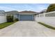 A long driveway leads to a blue garage with a fenced in yard at 10015 Brompton Dr, Tampa, FL 33626