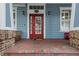 Close up of the front entrance shows a bright red door and well-maintained brick porch at 10015 Brompton Dr, Tampa, FL 33626