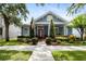 Charming home with a well-manicured lawn, colorful landscaping, and an inviting front porch at 10015 Brompton Dr, Tampa, FL 33626