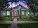 Beautifully landscaped home exterior with an American flag, red door, and colorful flowerbeds at 10015 Brompton Dr, Tampa, FL 33626
