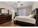 A comfortable main bedroom with wood floors, dresser, and ensuite bathroom at 10015 Brompton Dr, Tampa, FL 33626