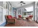 Inviting screened porch with wicker furniture, red cushions, and brick flooring at 10015 Brompton Dr, Tampa, FL 33626